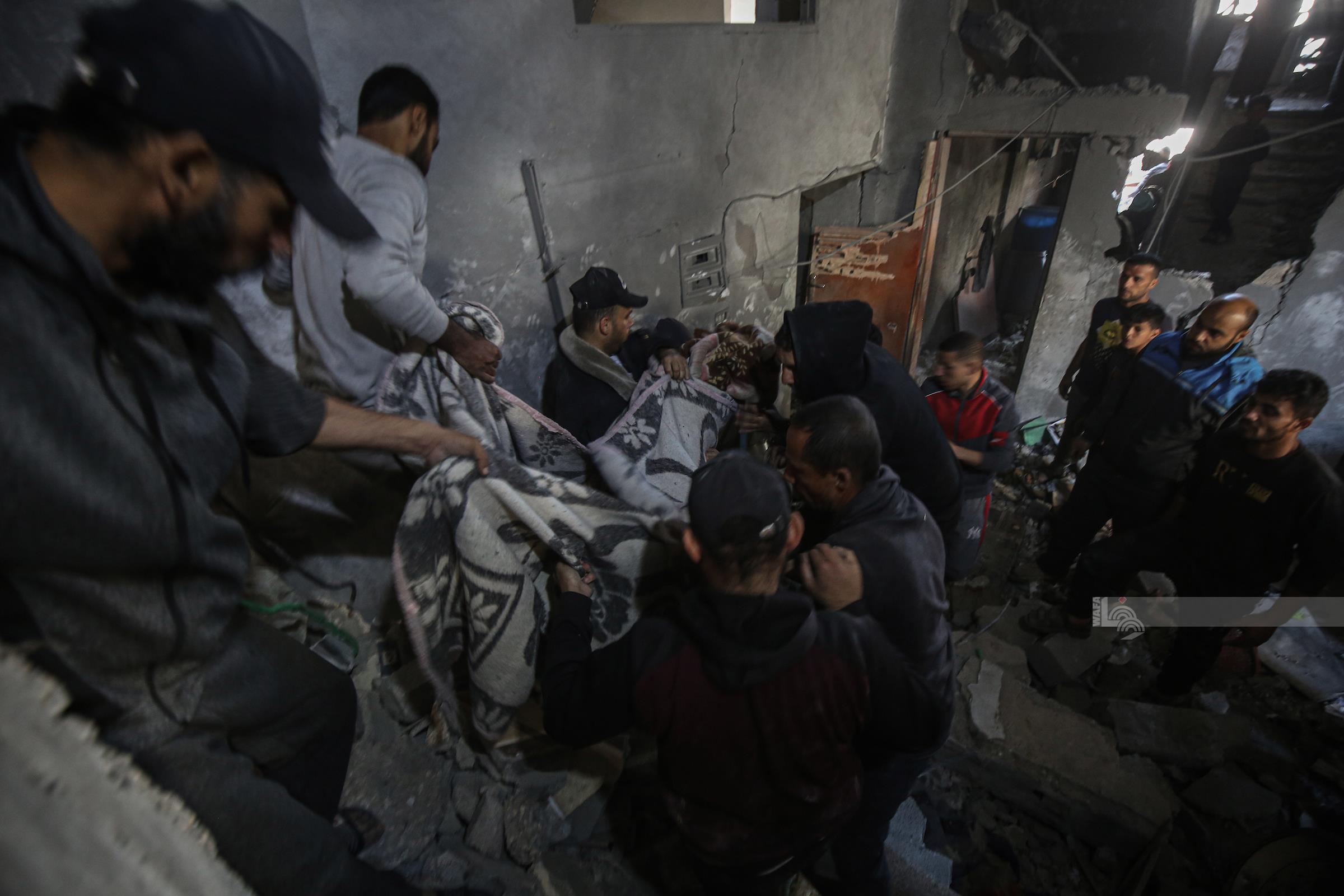 مواطنون ينتشلون جثامين شهداء بعد غارة للاحتلال على منزل في حي الصبرة جنوب مدينة غزة (وفا)